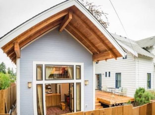 White ADU with wood gable roof and covered entry